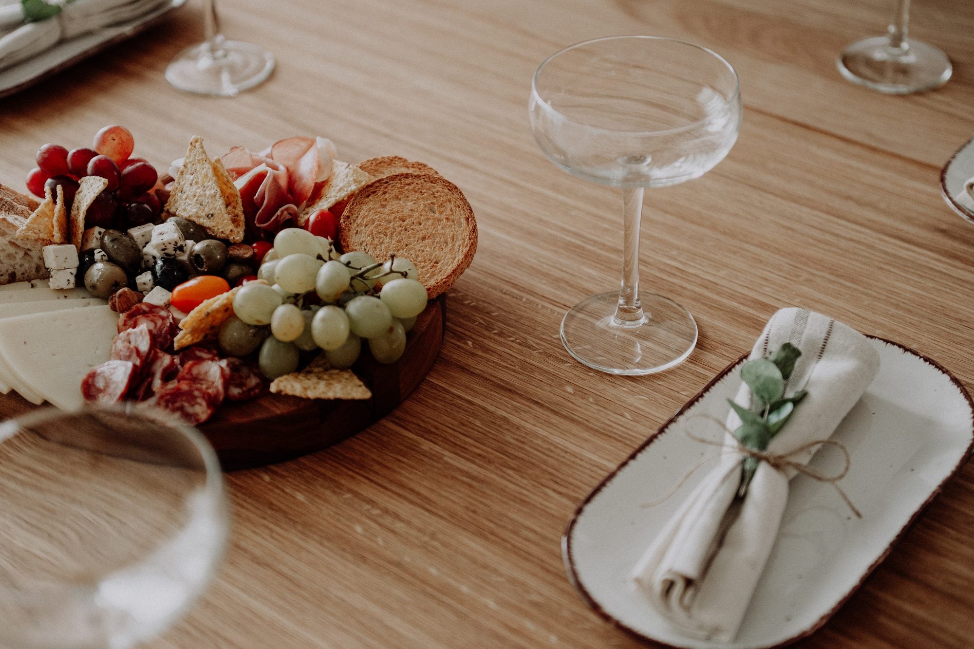 A shared board, glasses and napkins on the oak table