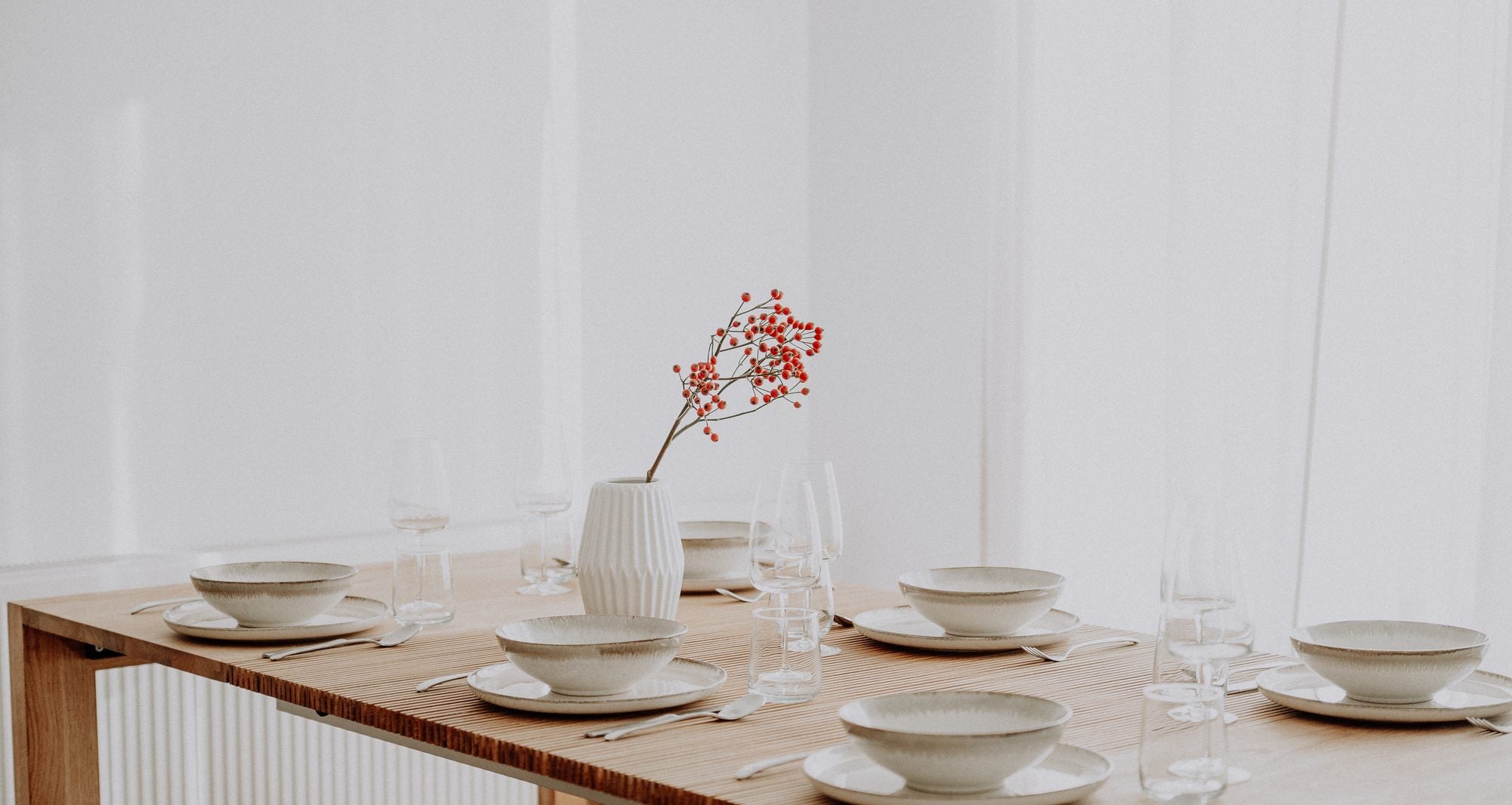 The oak table open, its lattice showing, set for dinner in a bright room