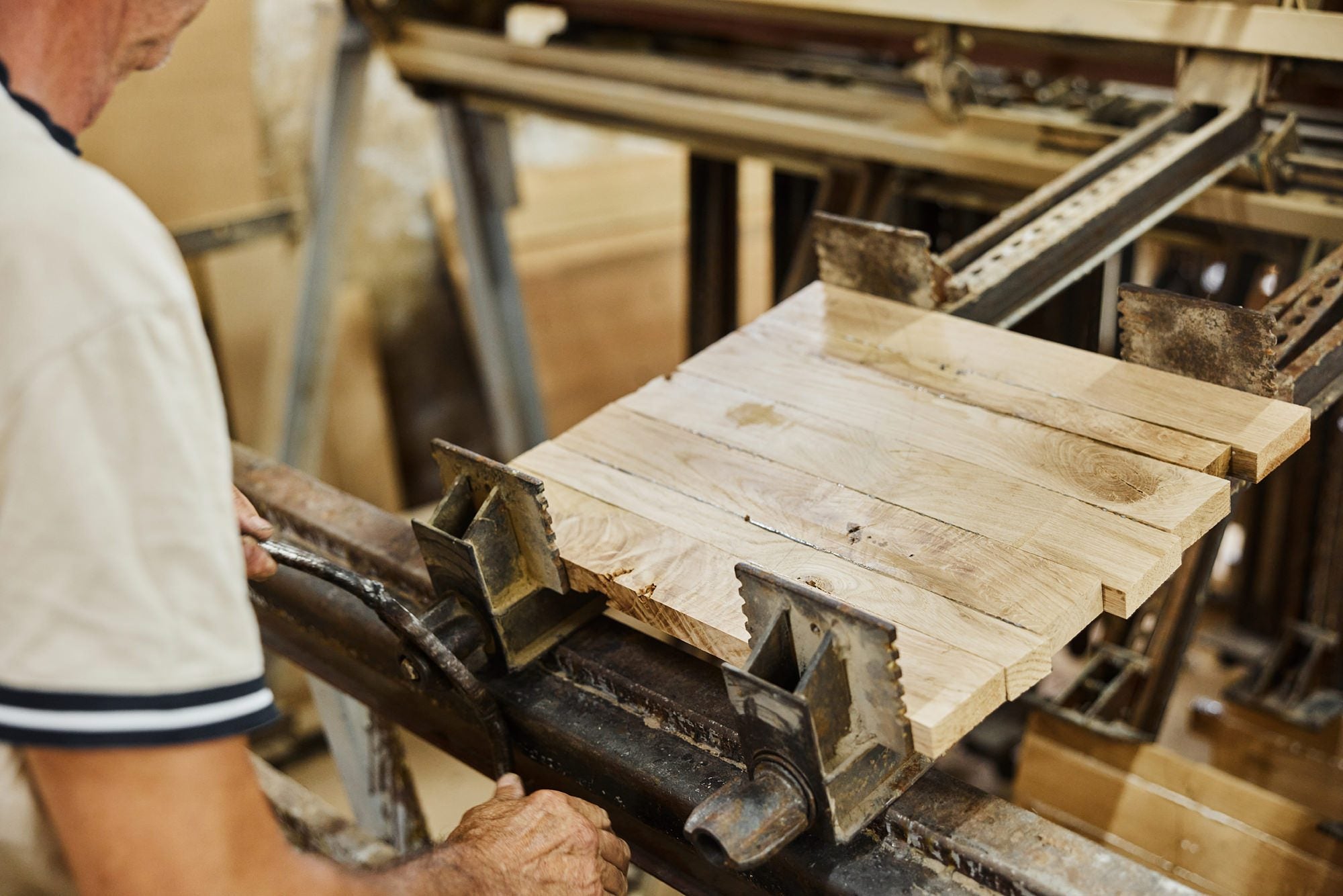 A maker sets oak boards into a panel clamp