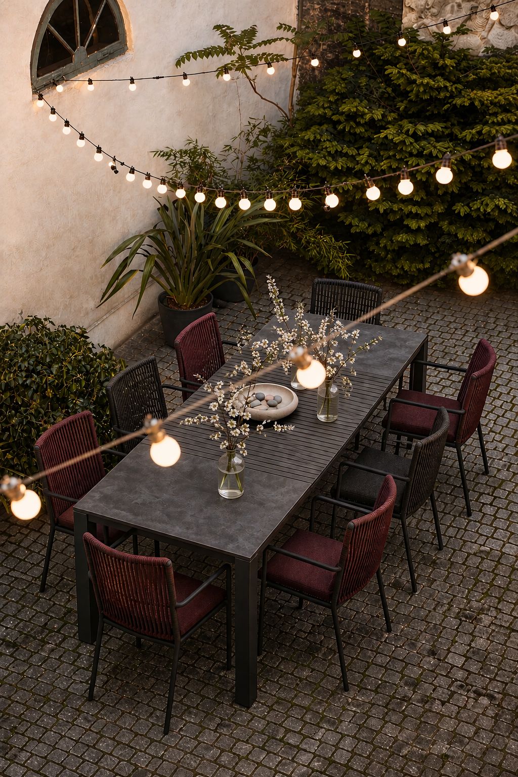 The outdoor table under string lights at night