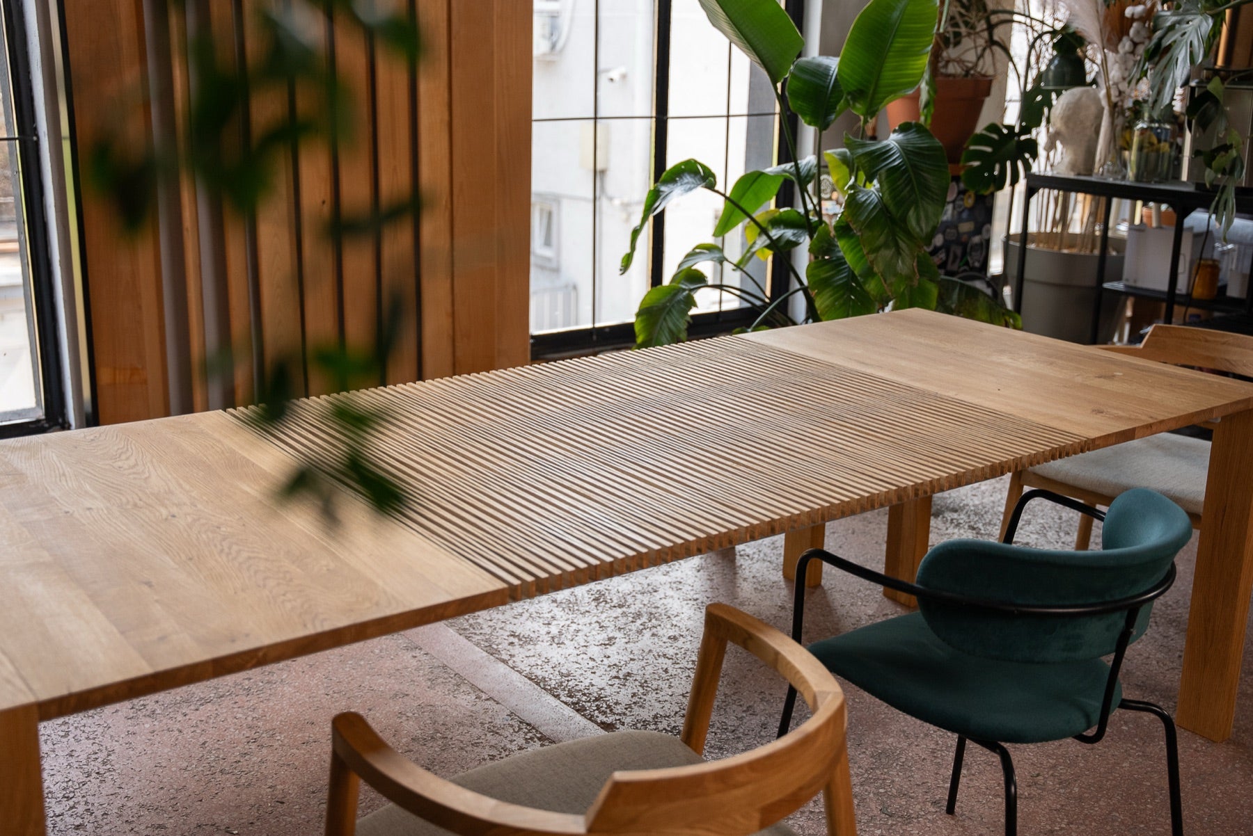 The oak table in a dining room with green chairs