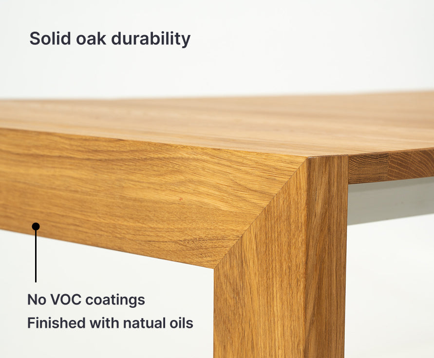 Wooden table corner with text highlighting solid oak durability, no VOC coatings, and natural oil finish.
