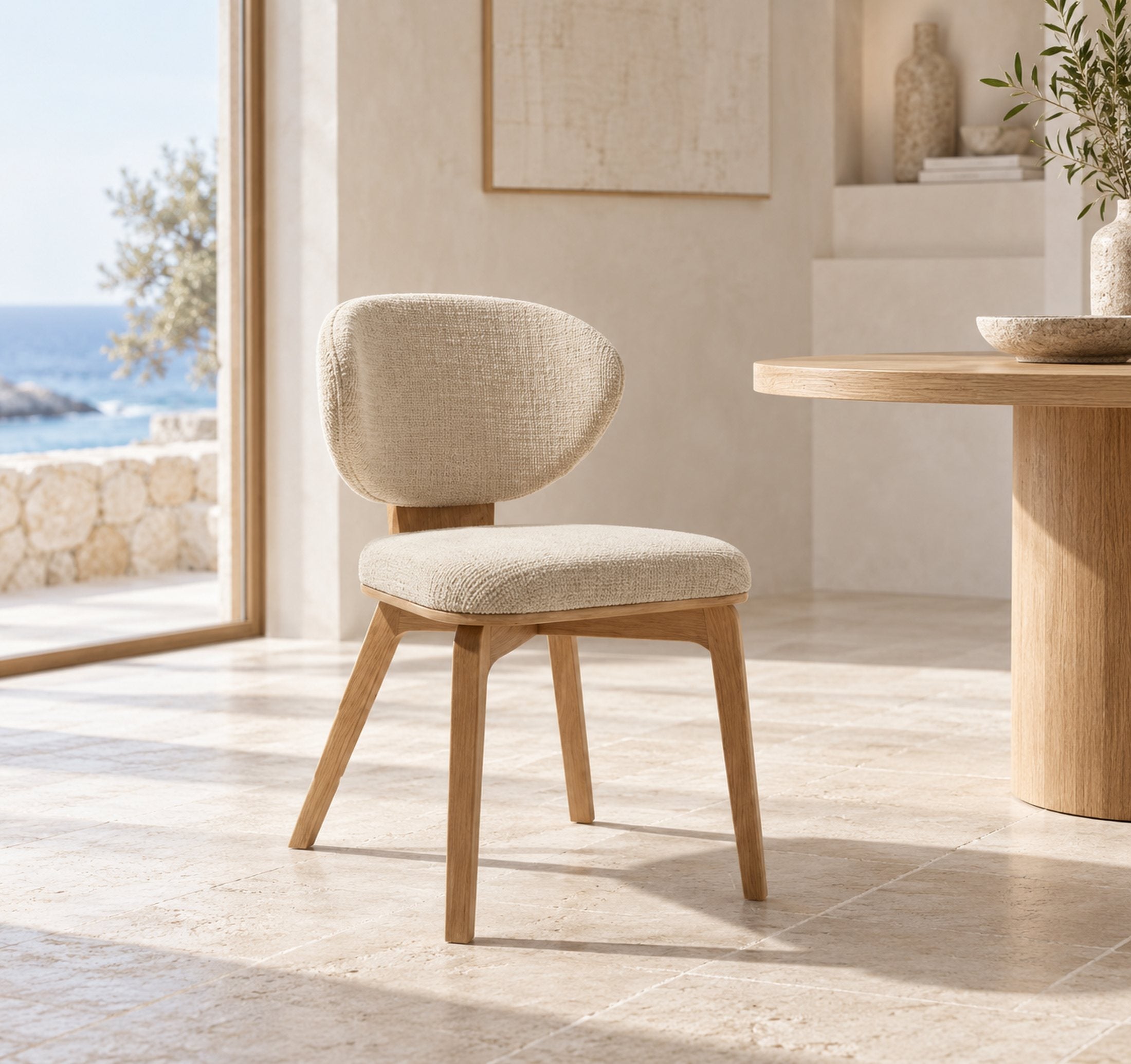 The Aria chair by a window overlooking the sea