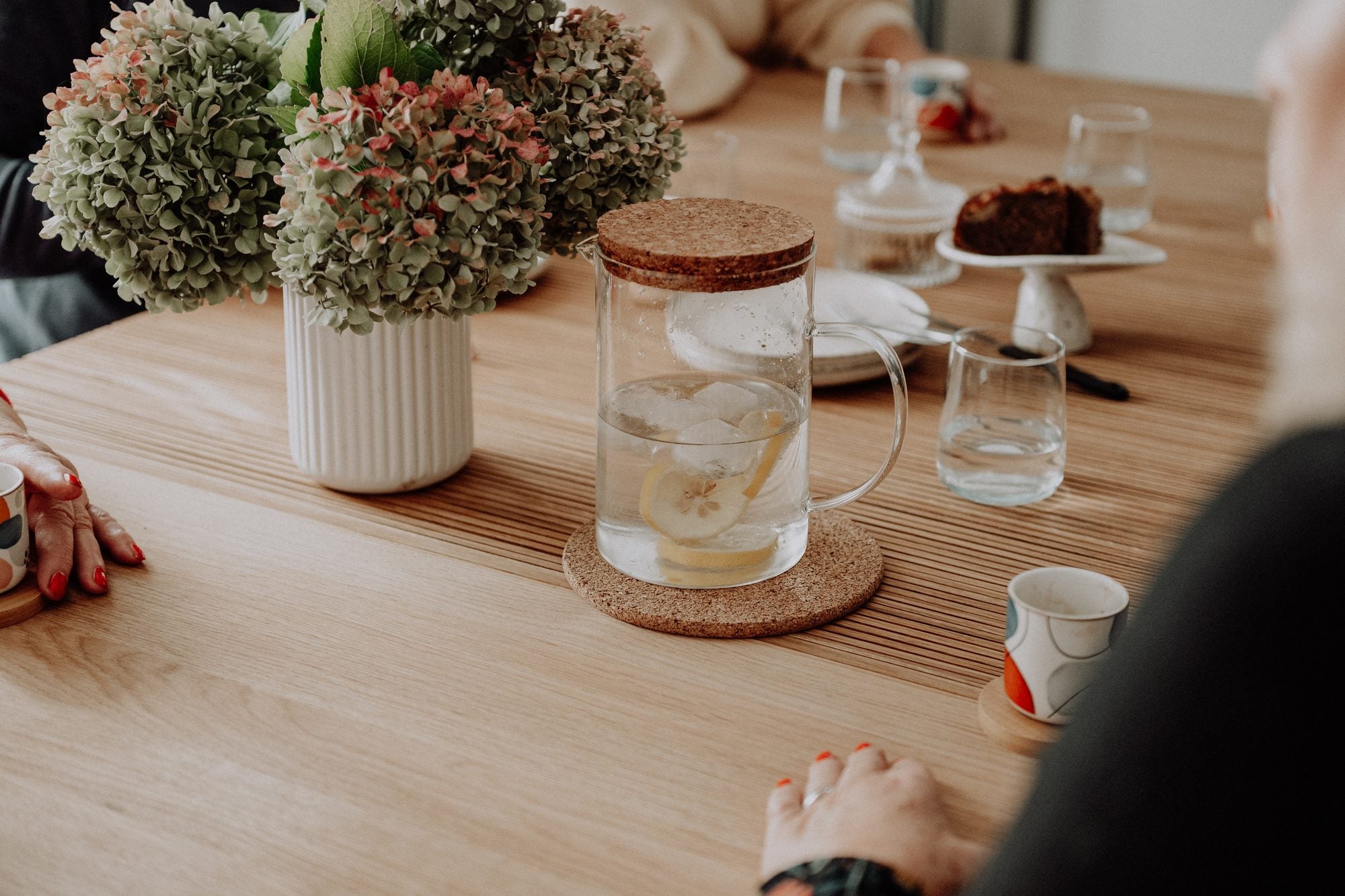 Hydrangeas, lemon water and cake on the oak table