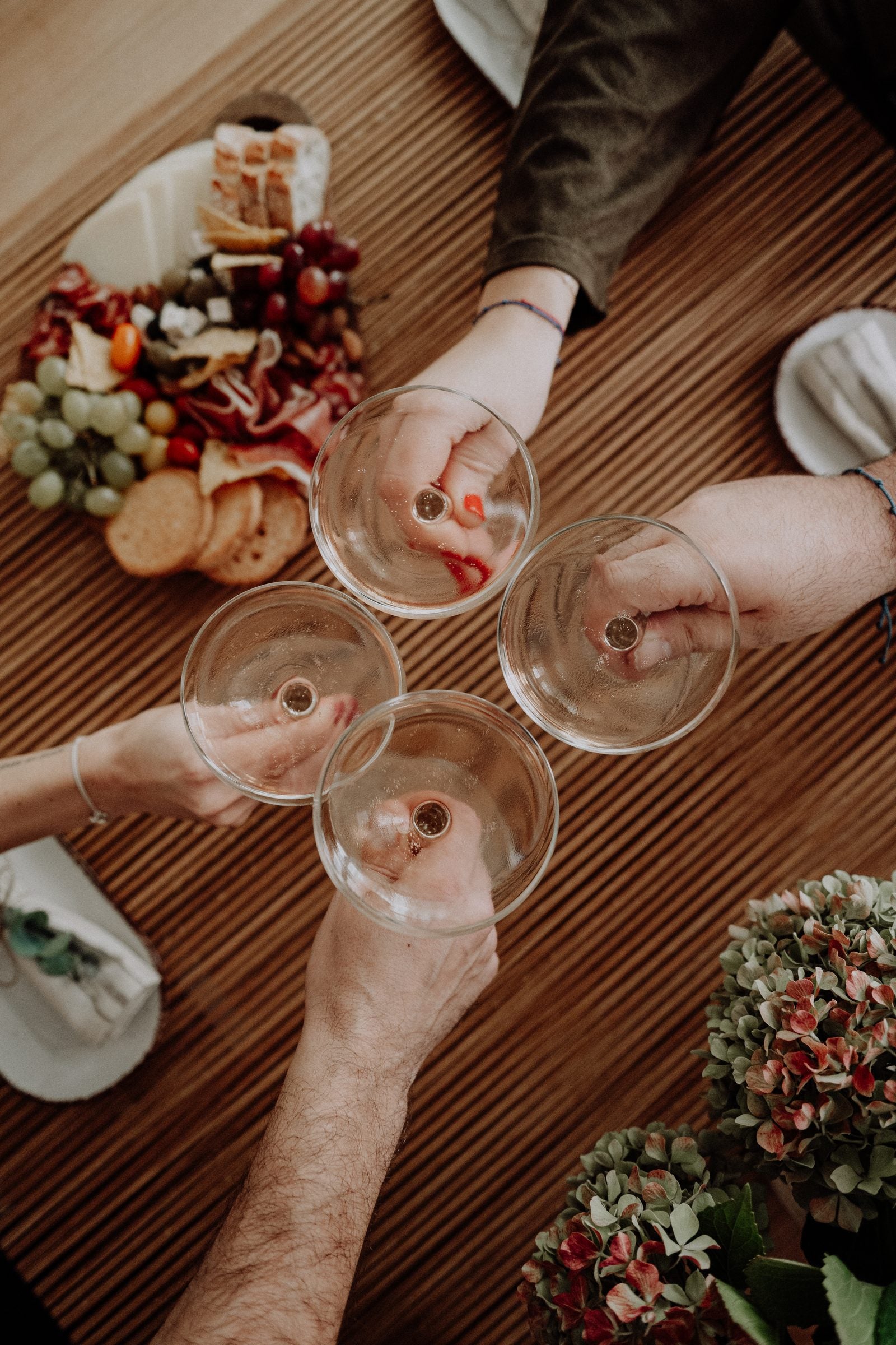 Glasses raised over plates of food on the oak table