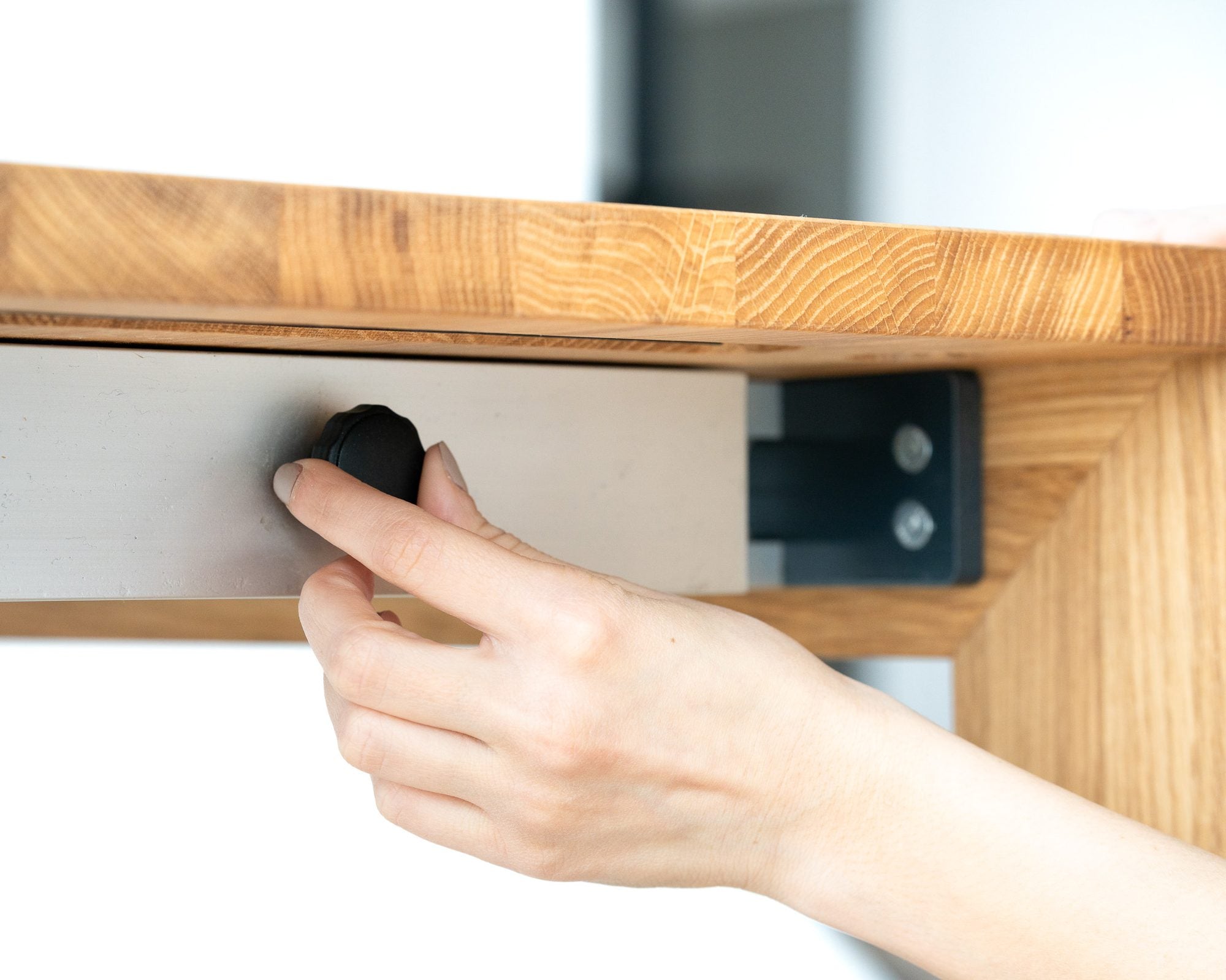 A hand on the locking wheel under the top